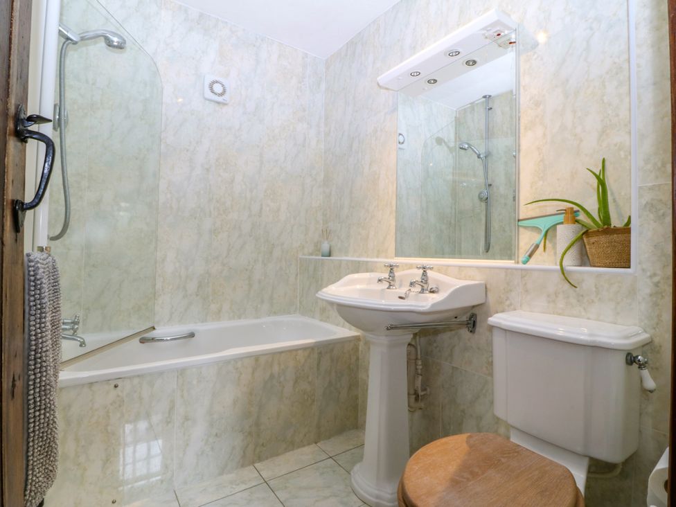 A bathroom with a bathtub, toilet, and sink at Tyddyn Iolyn in Benllech