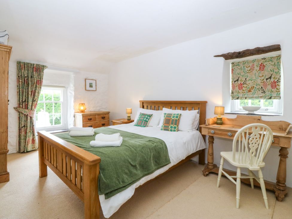 A bedroom with a bed and desk at Tyddyn Iolyn in Benllech