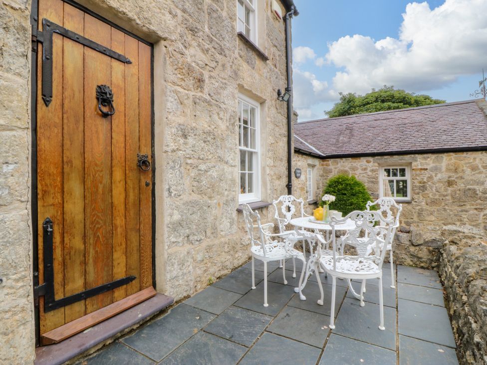 An outdoor seating area with a table and chairs at Tyddyn Iolyn in Benllech