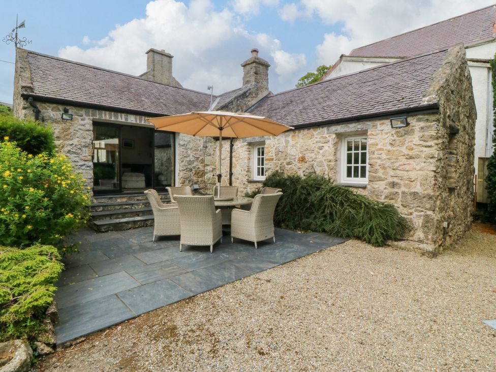 An outdoor seating area with a table and chairs at Tyddyn Iolyn in Benllech