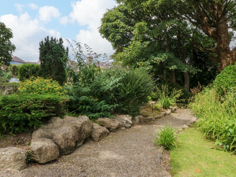 A garden with a pathway and various plants at Tyddyn Iolyn in Benllech