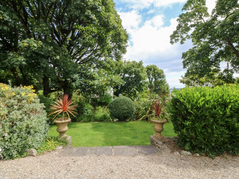 A garden with plant pots and shrubs at Tyddyn Iolyn in Benllech