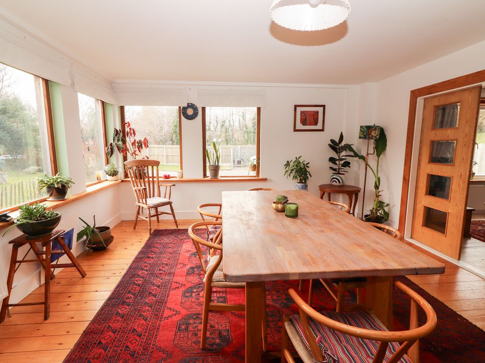 A dining room with a wooden table and chairs at Shanti Gher in Bantry