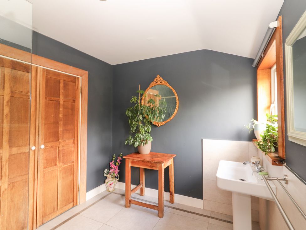A bathroom with a sink and wooden table at Shanti Gher in Bantry