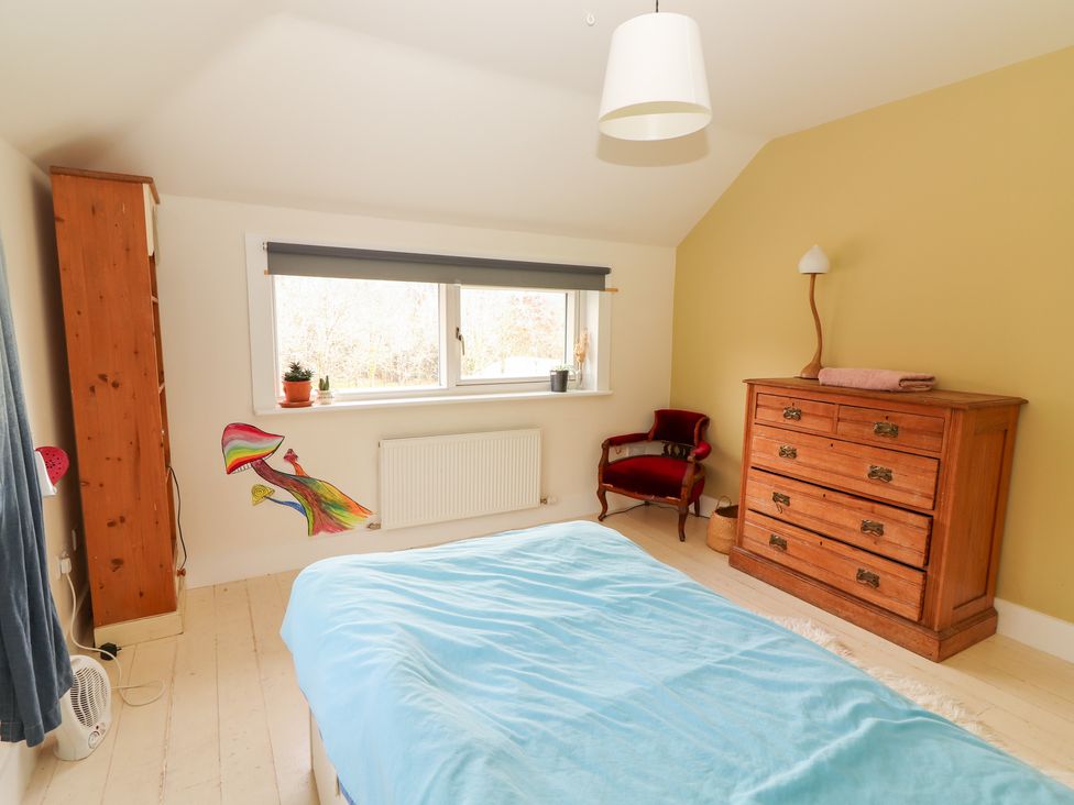A bedroom with a bed, dresser and chair at Shanti Gher in Bantry
