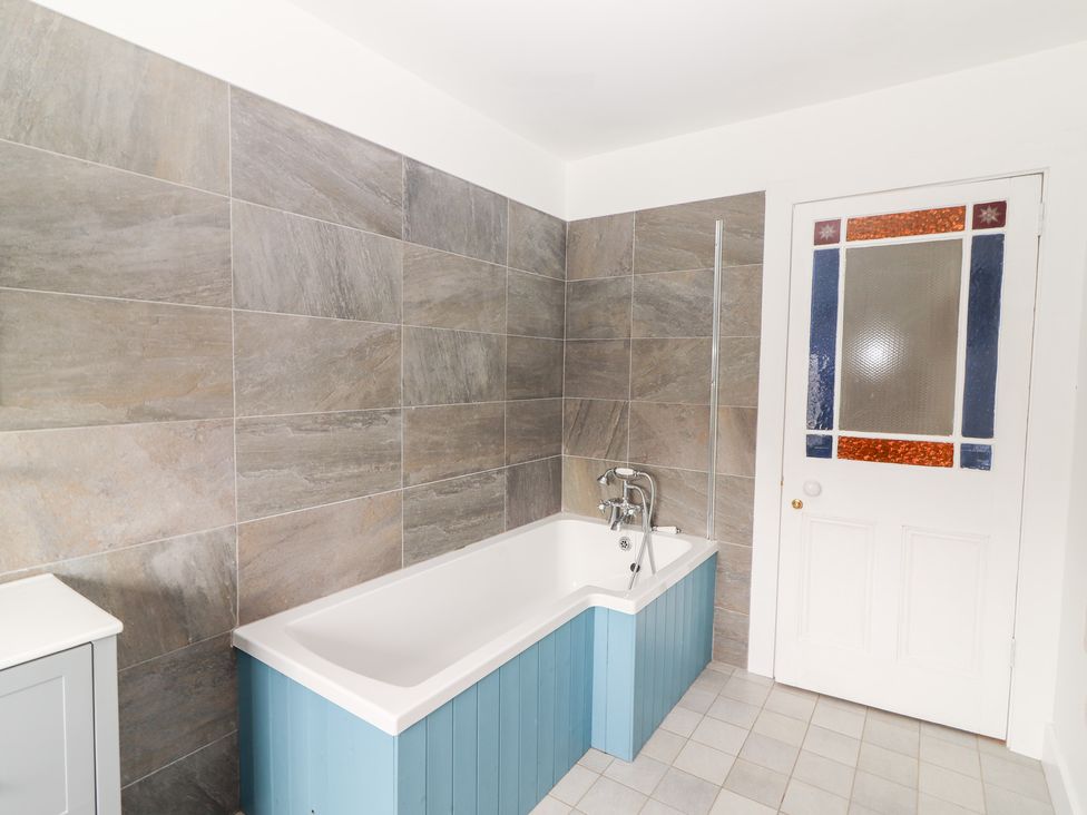 A bathroom with a bathtub and door at Shanti Gher in Bantry