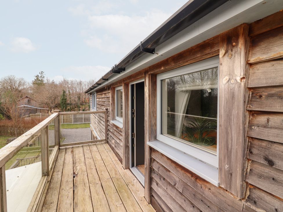 A wooden deck with windows and door at Shanti Gher in Bantry