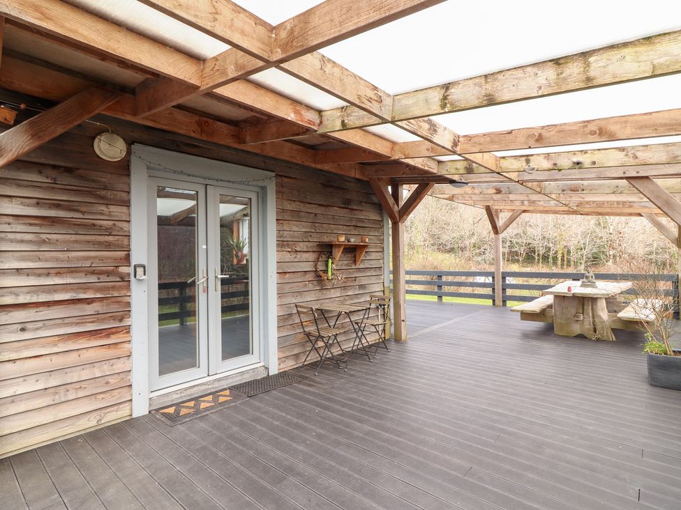 An outdoor area with a wooden deck and table at Shanti Gher in Bantry
