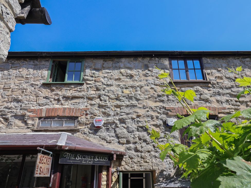 Stone building with two upper windows and a hair and nails salon on the ground floor with a sign reading The Secret Salon in Lyme Regis
