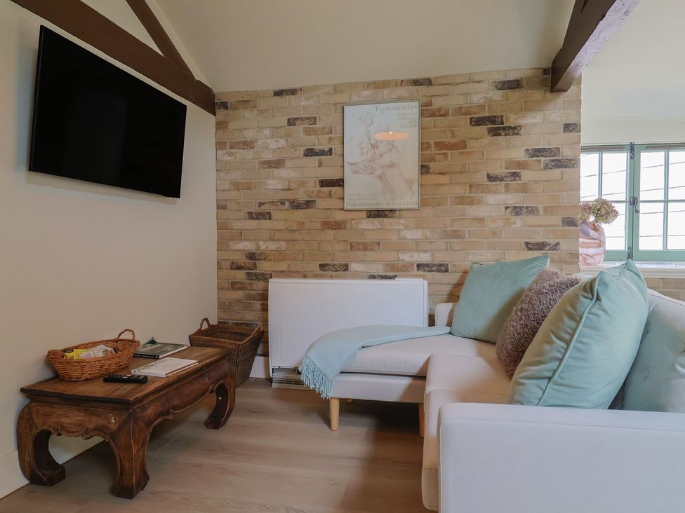 A living room with a sofa and television at Drake's Hideaway in Lyme Regis