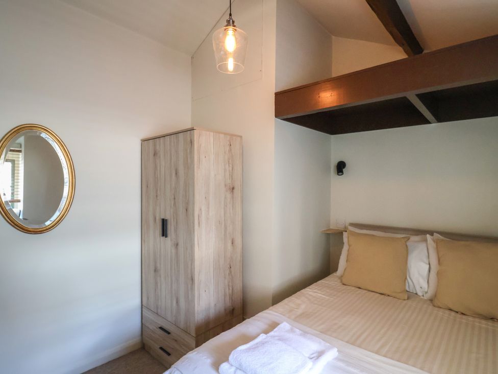A bedroom with a bed and wardrobe at Drake's Hideaway Lyme Regis