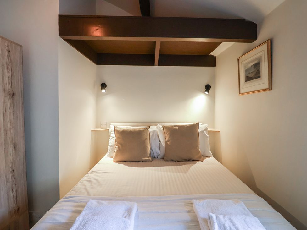 A bedroom with a bed and bedside lamps at Drake's Hideaway Lyme Regis