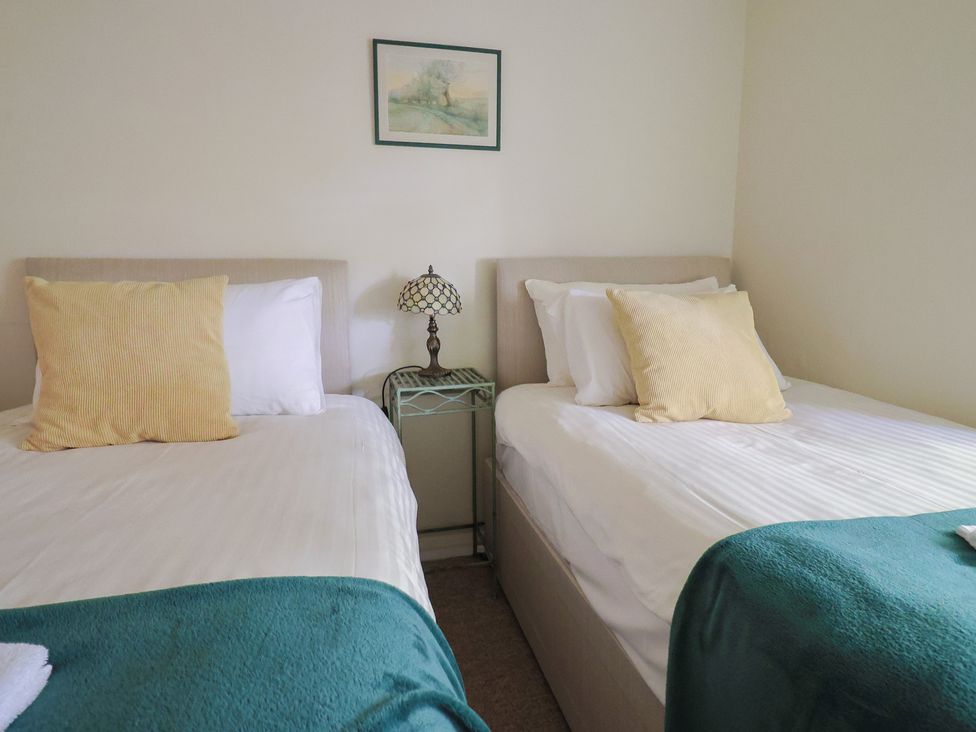 A bedroom with two beds and a lamp at Drake's Hideaway in Lyme Regis