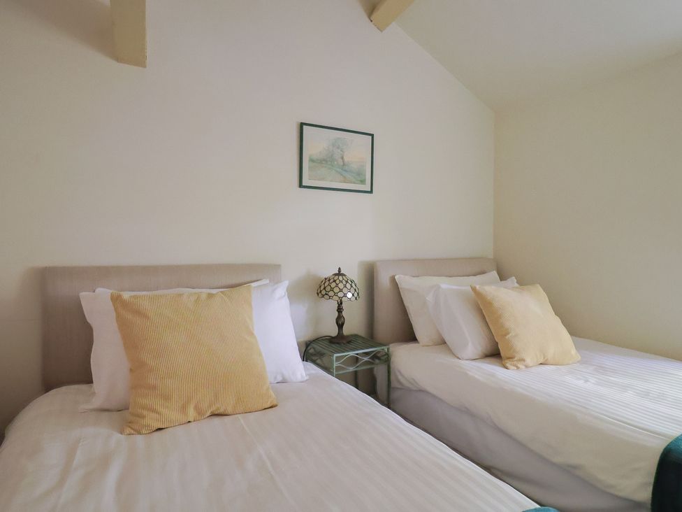 A bedroom with two beds and a lamp at Drake's Hideaway in Lyme Regis