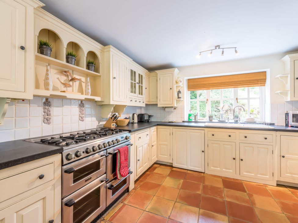 A kitchen with cabinets and appliances at The Coach House in Lydford
