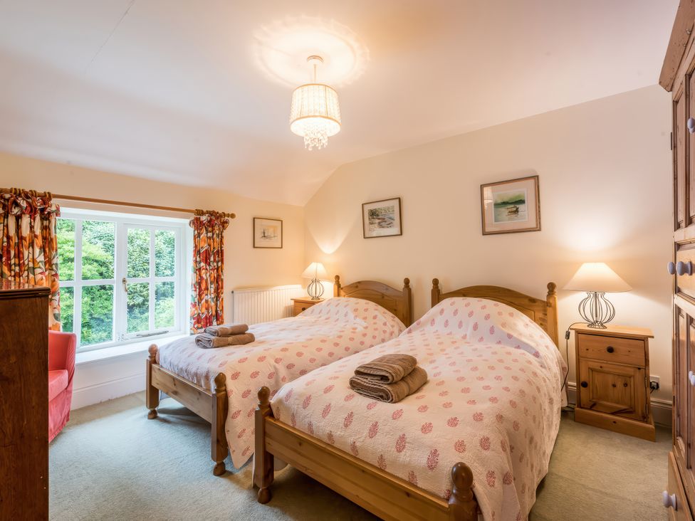 A bedroom with twin beds and a window at The Coach House in Lydford