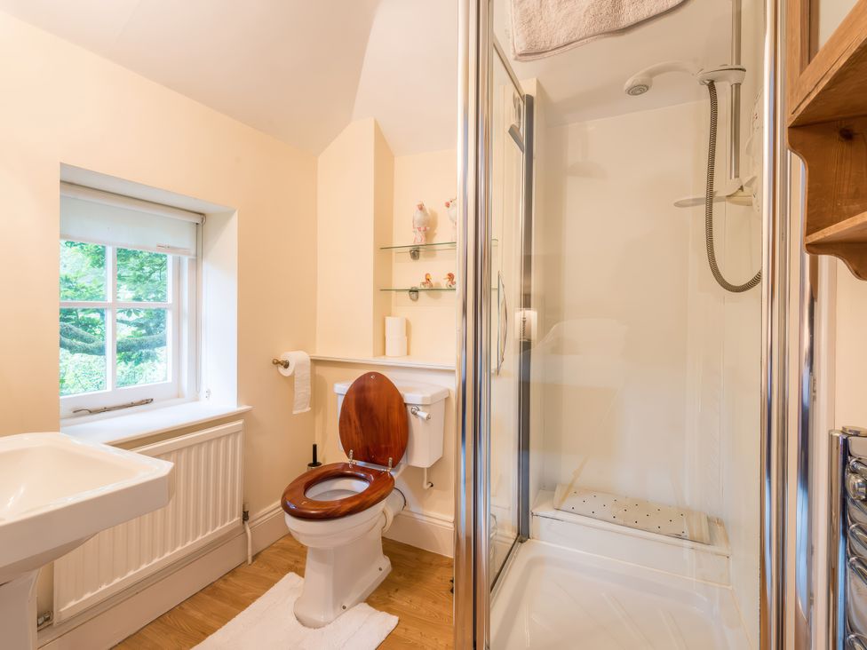 A bathroom with a toilet, shower, and sink at The Coach House in Lydford