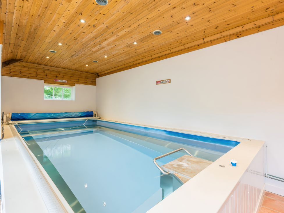 An indoor pool with wooden ceiling at The Coach House in Lydford