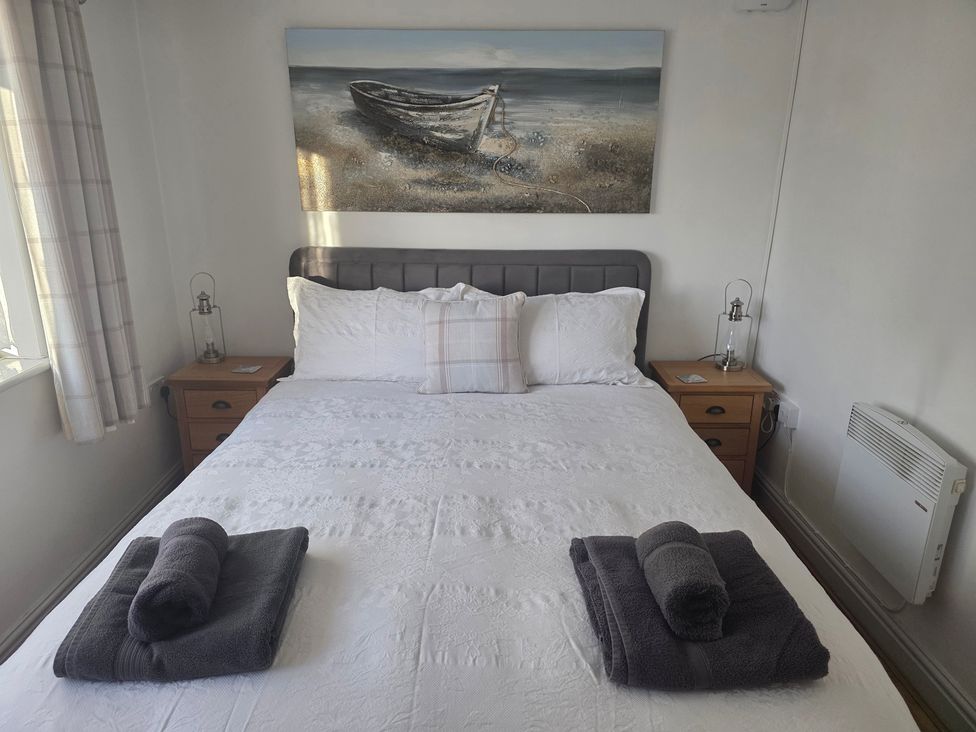 A bedroom with a double bed and bedside tables at Camwy in Brynsiencyn