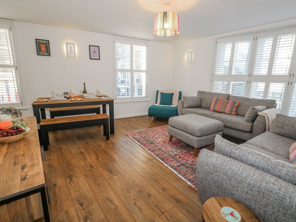 A living room with a sofa and dining area at Betty's Buoy Weymouth