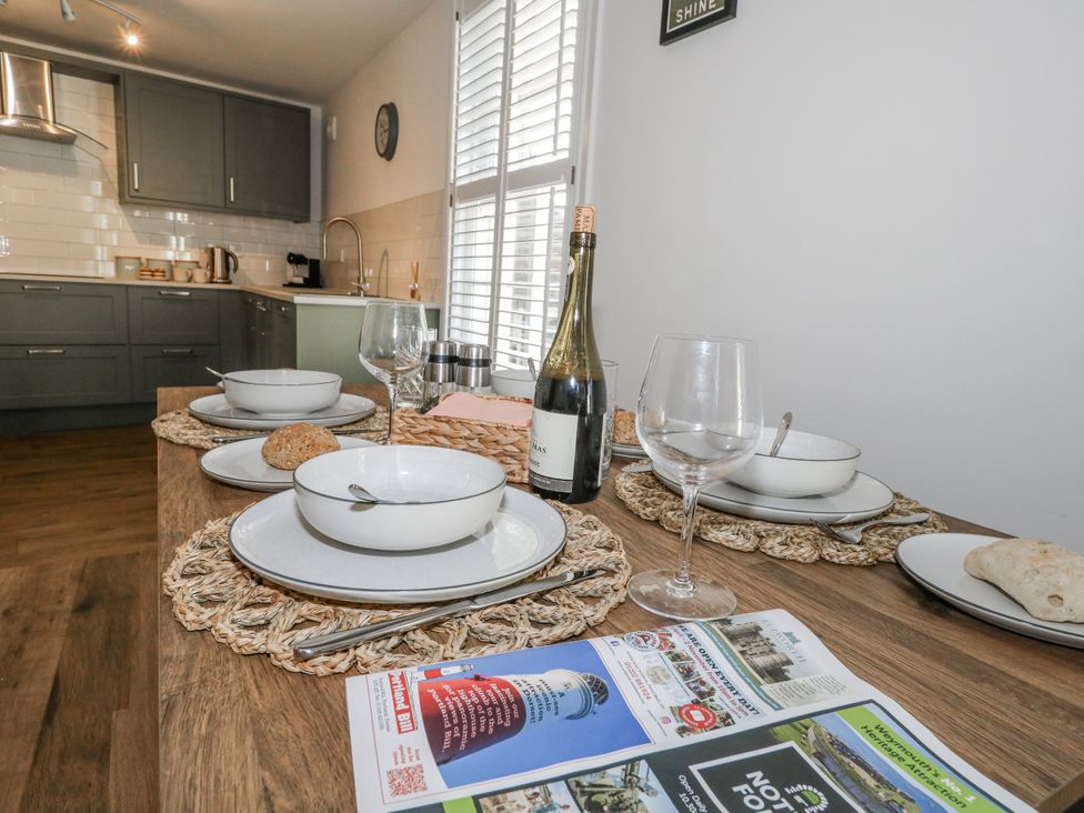 A kitchen with a dining table set up for a meal at Betty's Buoy in Weymouth