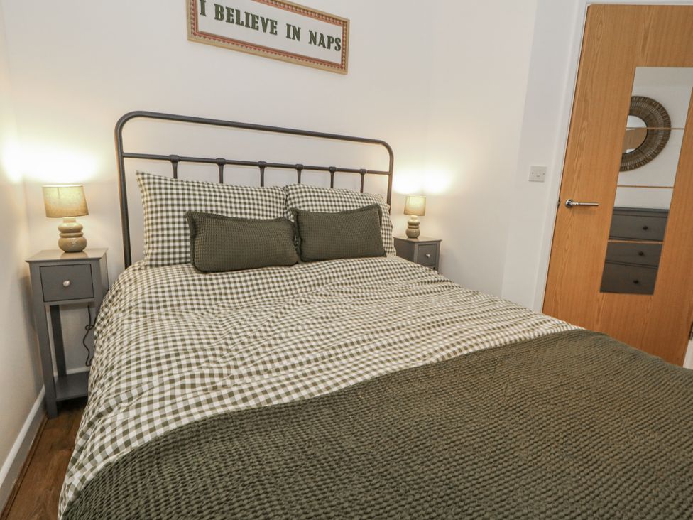 A bedroom with a bed and nightstand at Betty's Buoy in Weymouth