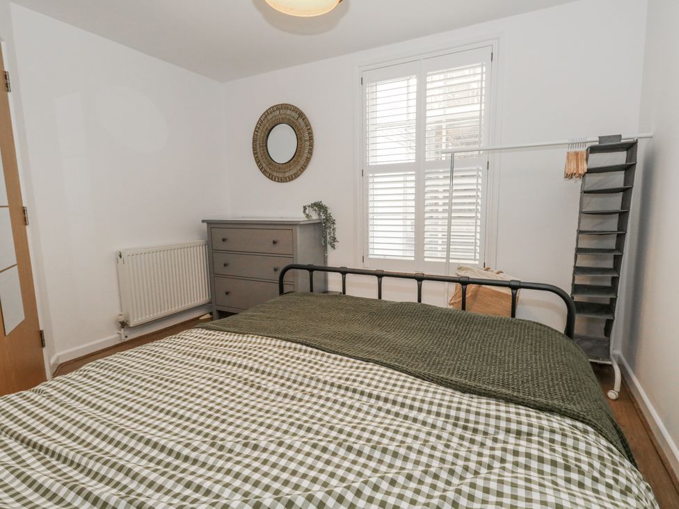 A bedroom with a bed and dresser at Betty's Buoy in Weymouth