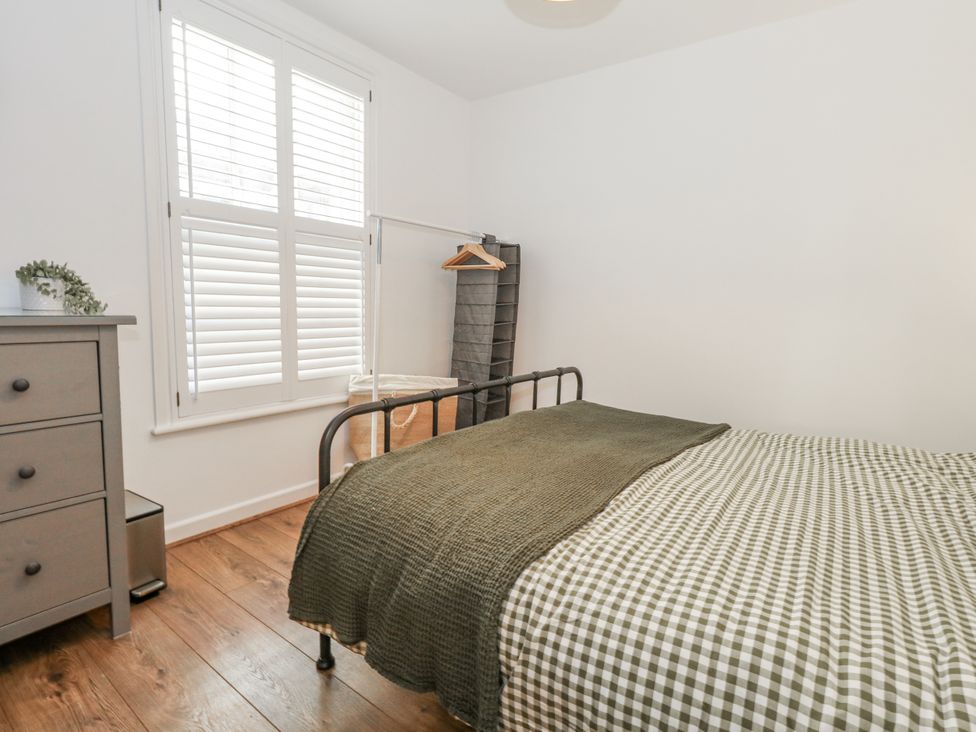 A bedroom with a bed and dresser at Betty's Buoy in Weymouth