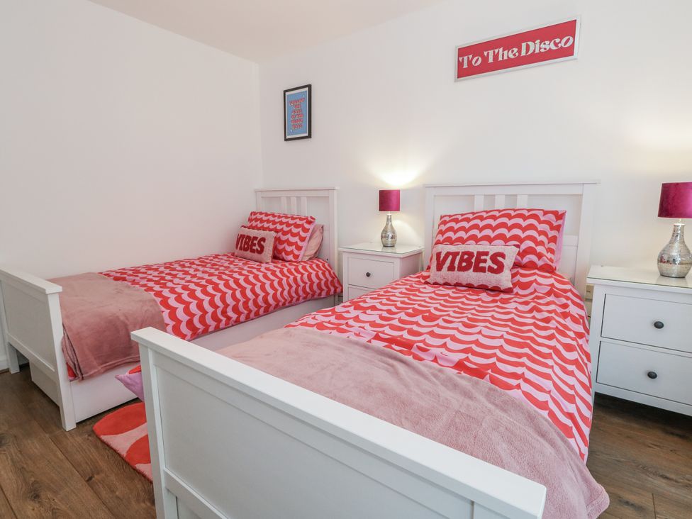 A bedroom with two beds and bedside tables at Betty's Buoy in Weymouth