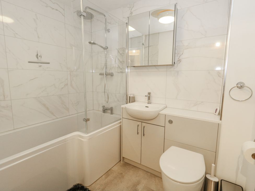 A bathroom with a bathtub, shower, sink, and toilet at Betty's Buoy in Weymouth