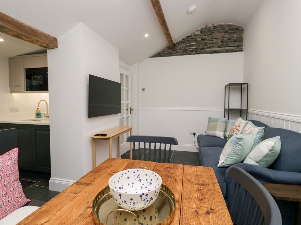 An open plan living area with a sofa and dining table at Pippins in Ambleside