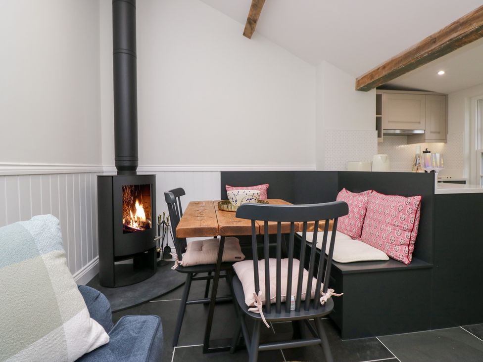 A dining room with a wooden table and black chairs at Pippins in Ambleside
