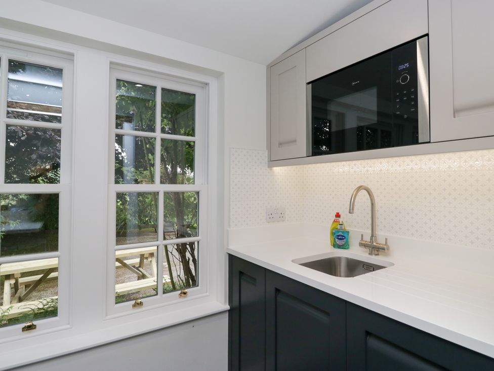 A kitchen with a sink and microwave at Pippins in Ambleside