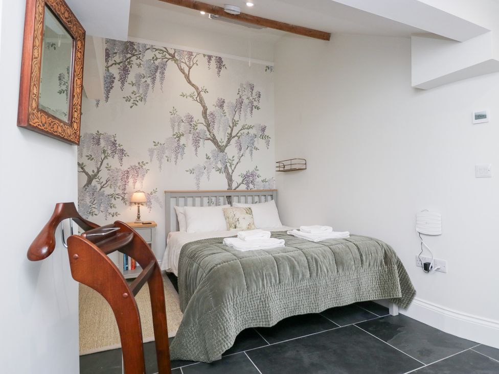 A bedroom with a bed and bedside table at Pippins in Ambleside