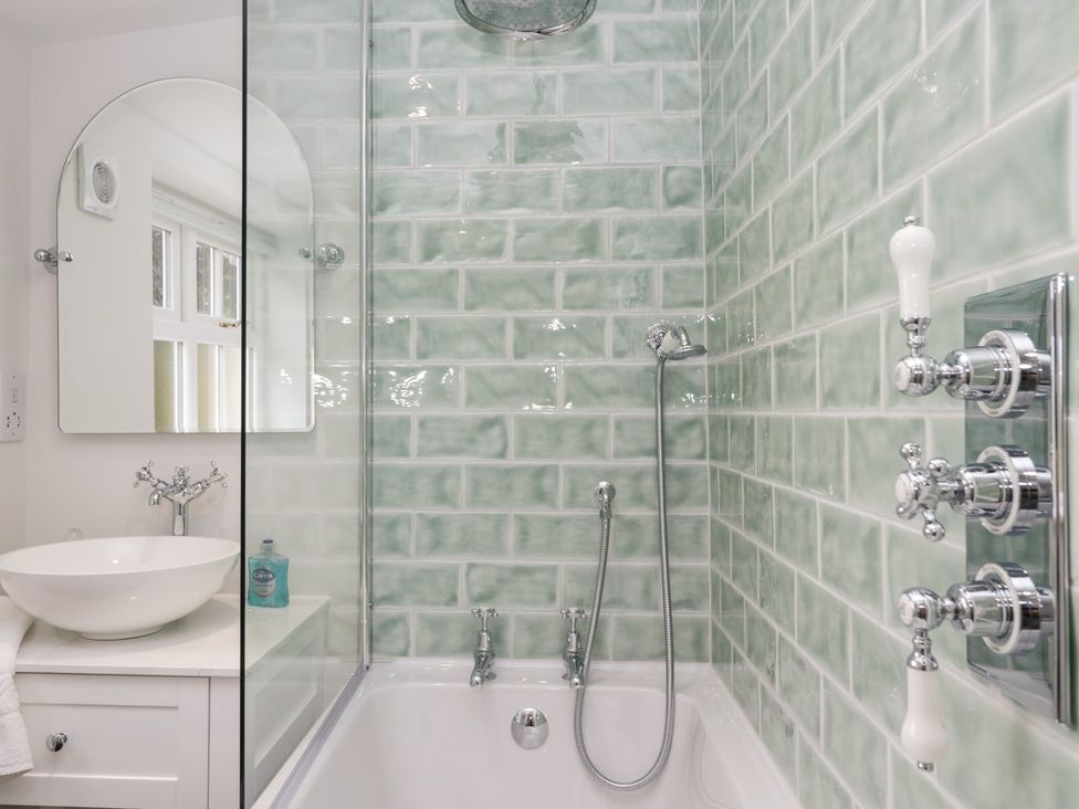 A bathroom with a bathtub and sink at Pippins Ambleside