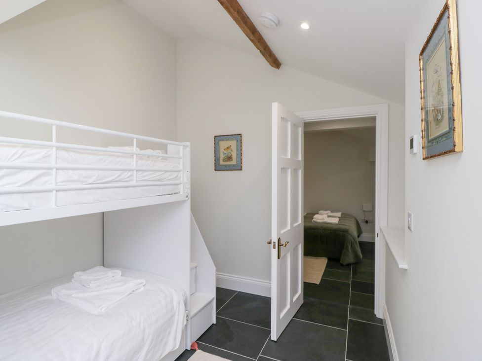 A bedroom with a bunk bed and a door leading to another room at Pippins in Ambleside