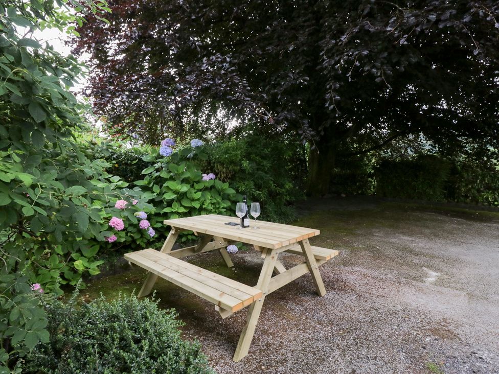 A garden with a picnic table and glasses at Pippins in Ambleside