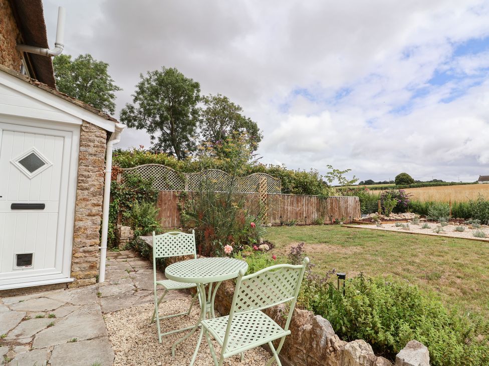 A garden with a table and chairs at Thatchers End in Sherborne