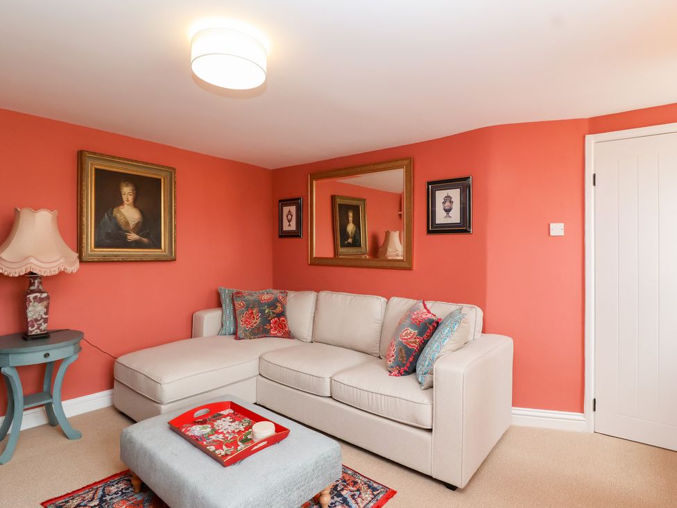 A living room with a sofa and artwork at Thatchers End in Sherborne