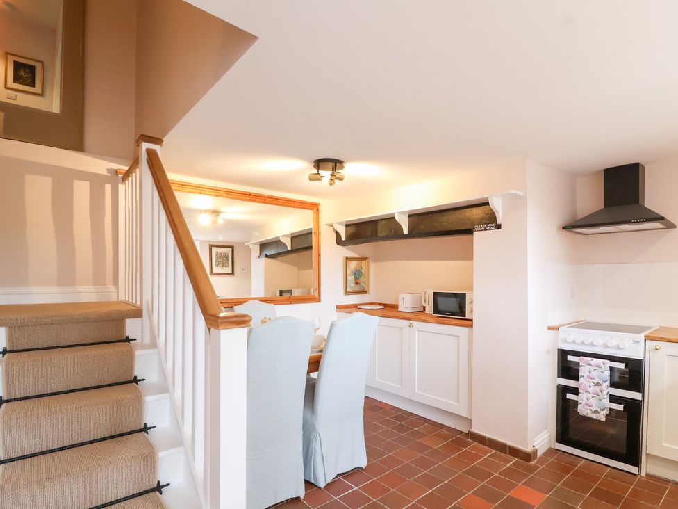 A kitchen with dining table and oven at Thatchers End Sherborne