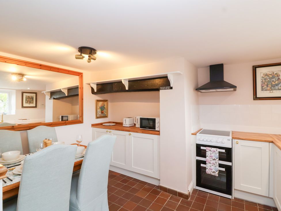 A kitchen with a dining area and appliances at Thatchers End in Sherborne