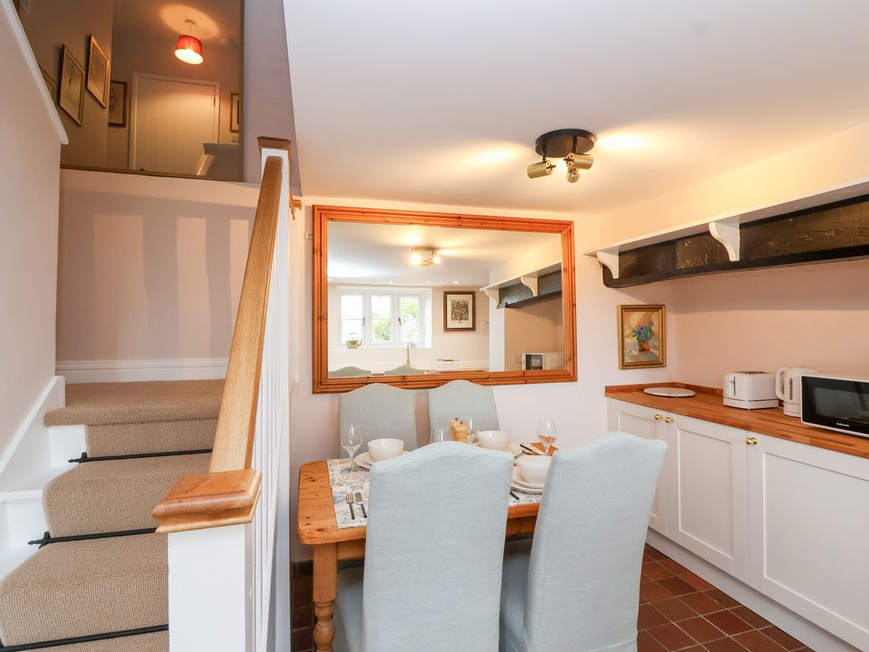 A kitchen with a table and chairs at Thatchers End in Sherborne