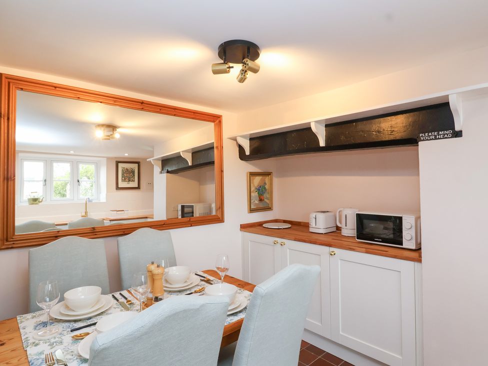 A kitchen with a dining table and appliances at Thatchers End in Sherborne