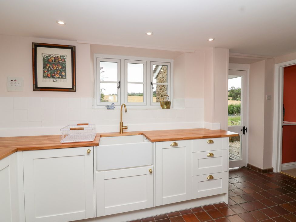A kitchen with a sink and cabinets at Thatchers End in Sherborne