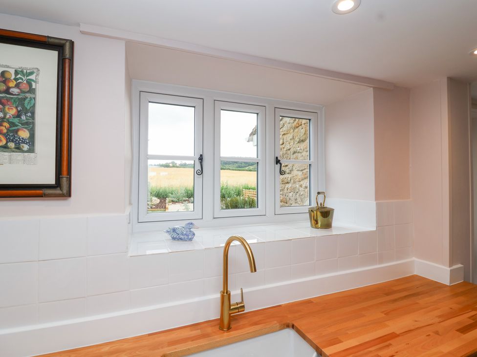 A kitchen with a window and sink area at Thatchers End in Sherborne