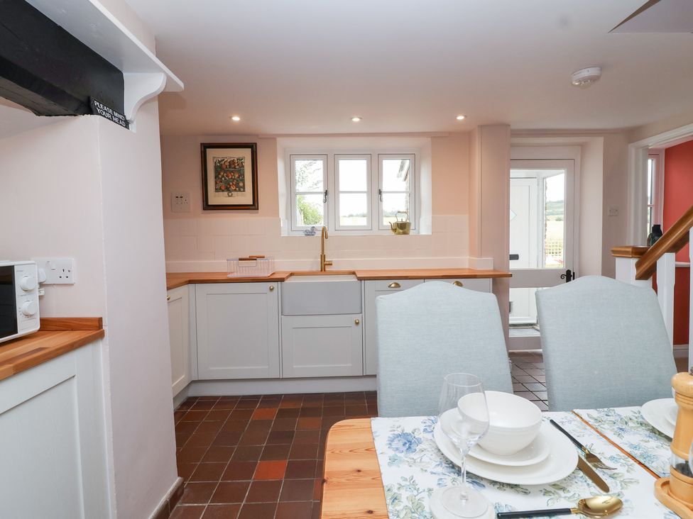 A kitchen with a sink and cabinets at Thatchers End in Sherborne