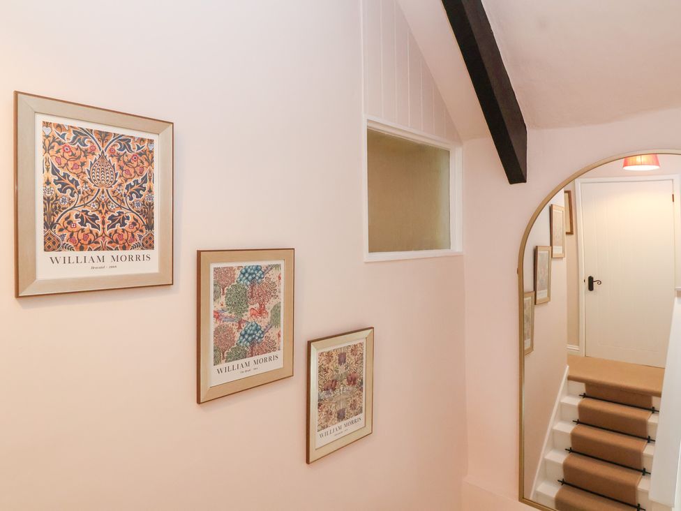 A hallway with wall art and staircase at Thatchers End in Sherborne