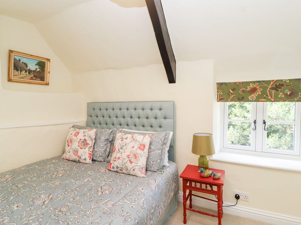 A bedroom with a bed and a bedside table at Thatchers End in Sherborne
