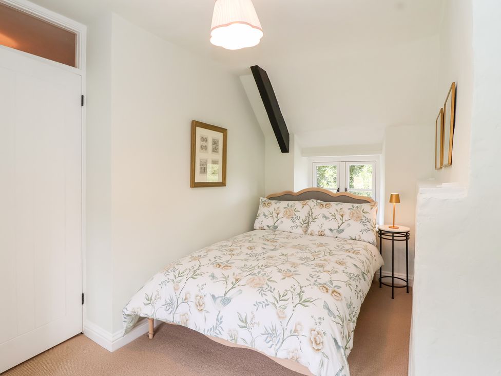 A bedroom with a bed and bedside table at Thatchers End in Sherborne
