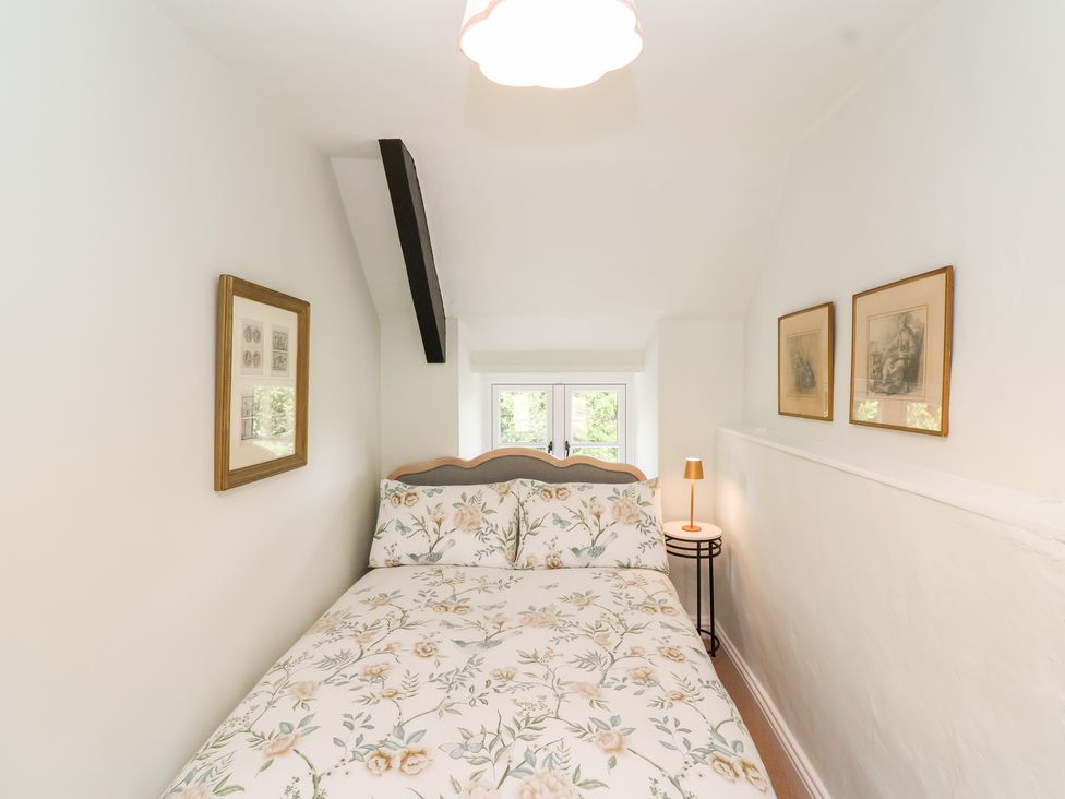 A bedroom with a bed and bedside table at Thatchers End in Sherborne